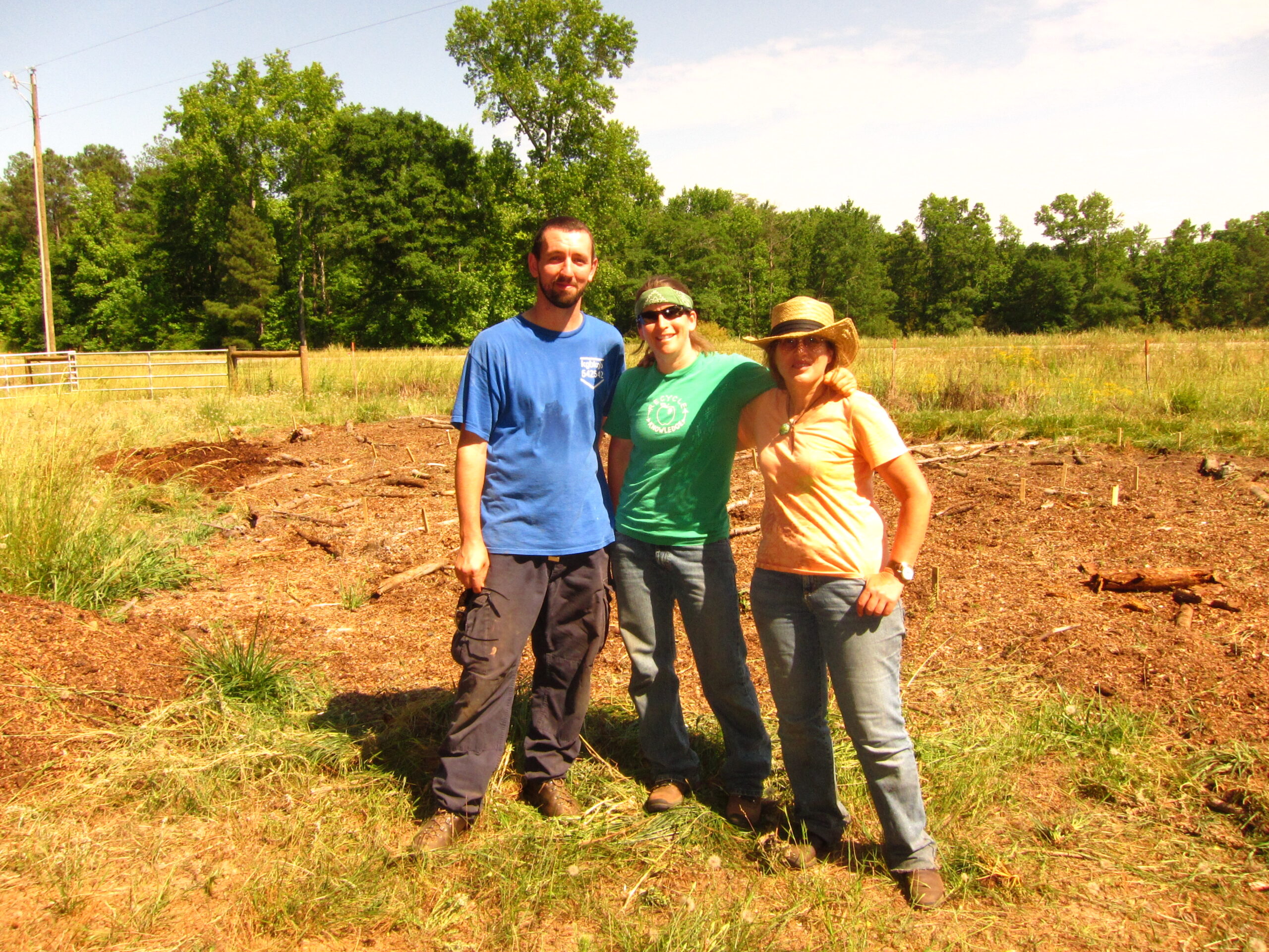 Jeff Killingsorth, Lauren Sandoval and Pandra Williams pose in an open field in June of 2010. Behind them is exposed soil which will be amended to create sunbeds at the Lexington farm.