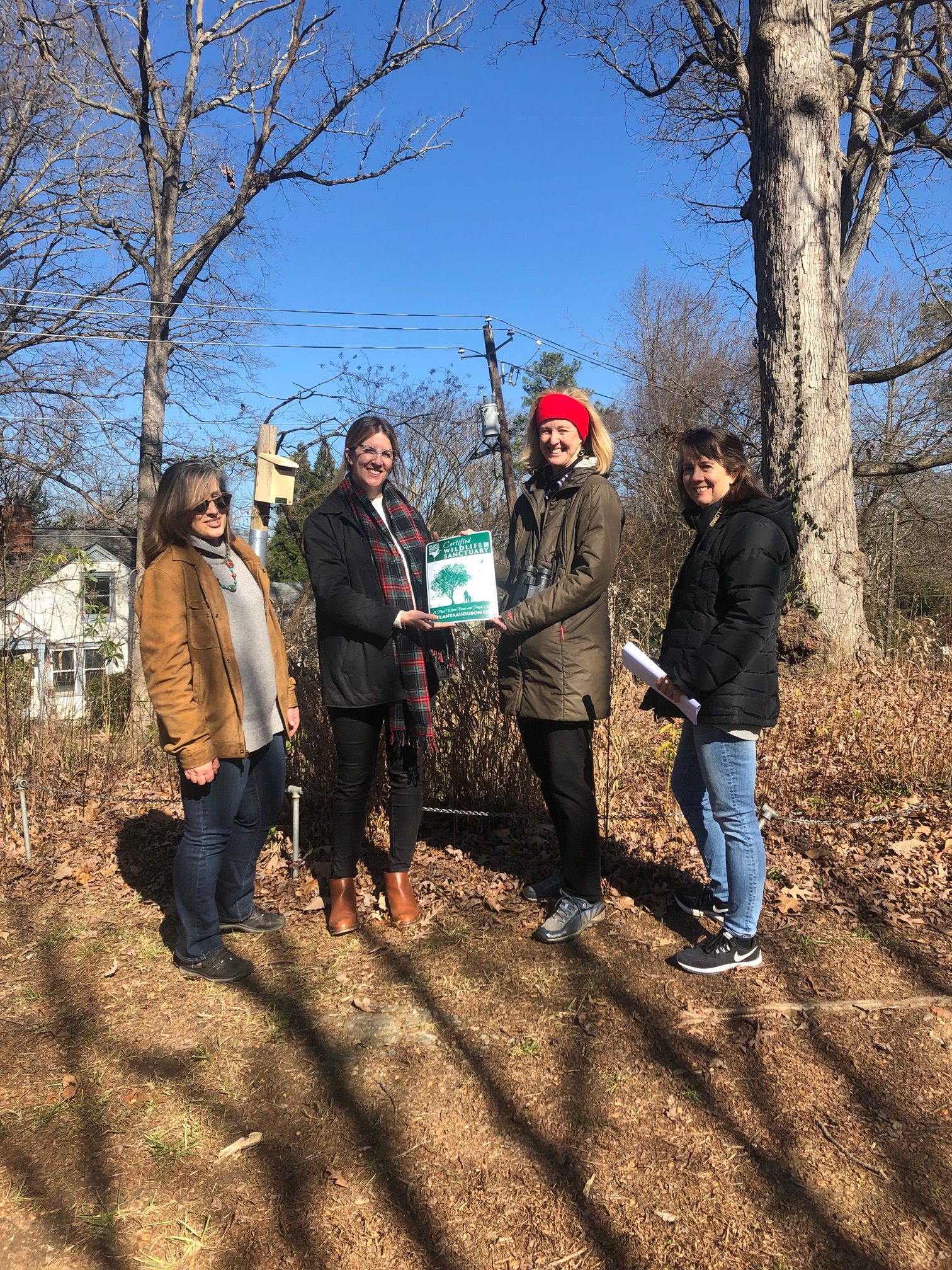 Community project: Pandra Williams looking on as Laura Hennighausen, Executive Director, is being presented with the Wildlife Habitat Certification sign by Atlanta Audubon Society Board Members Melinda Langston and Leslie Edwards.