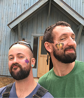 Jessi and Jeff with face paintings of a monarch butterfly and purple coneflower.