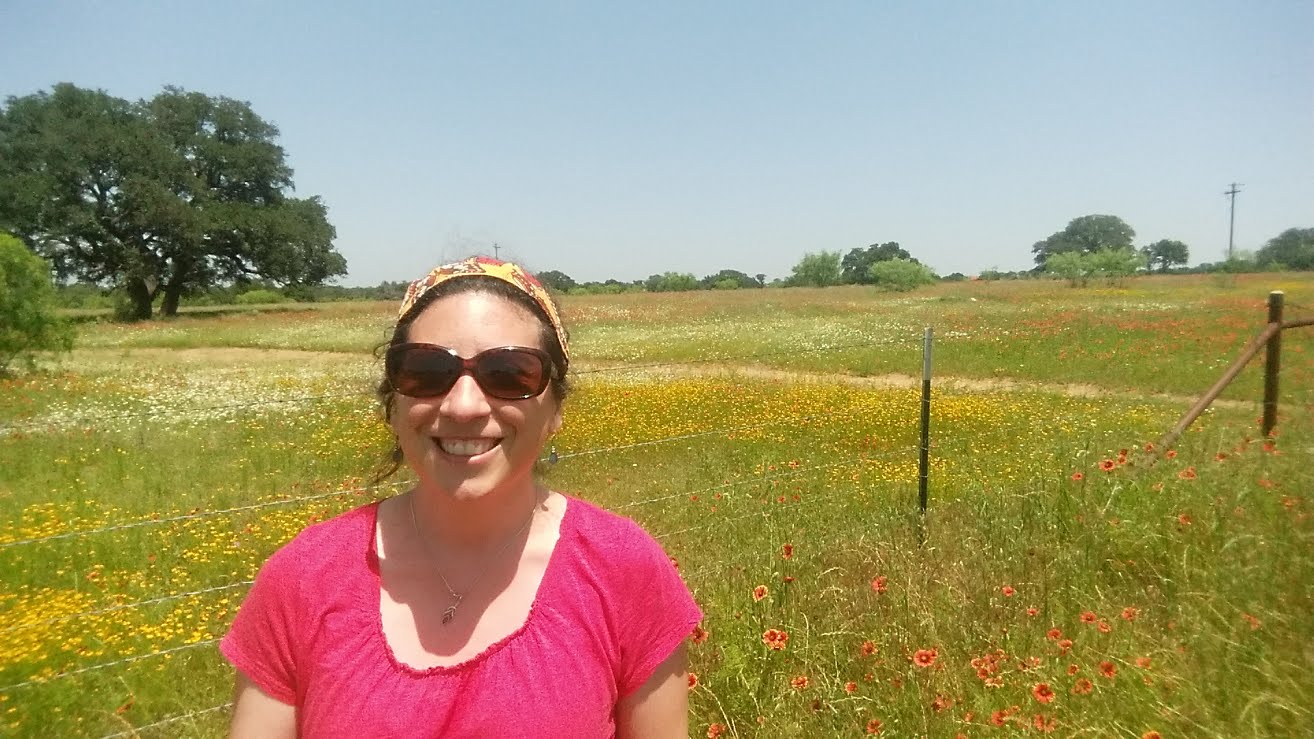 Andrea Greco in front of a field of wildflowers
