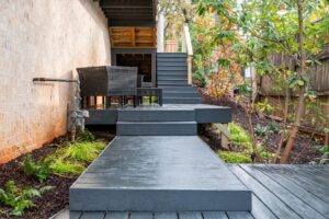 gray painted wooden deck with stairs and plants.